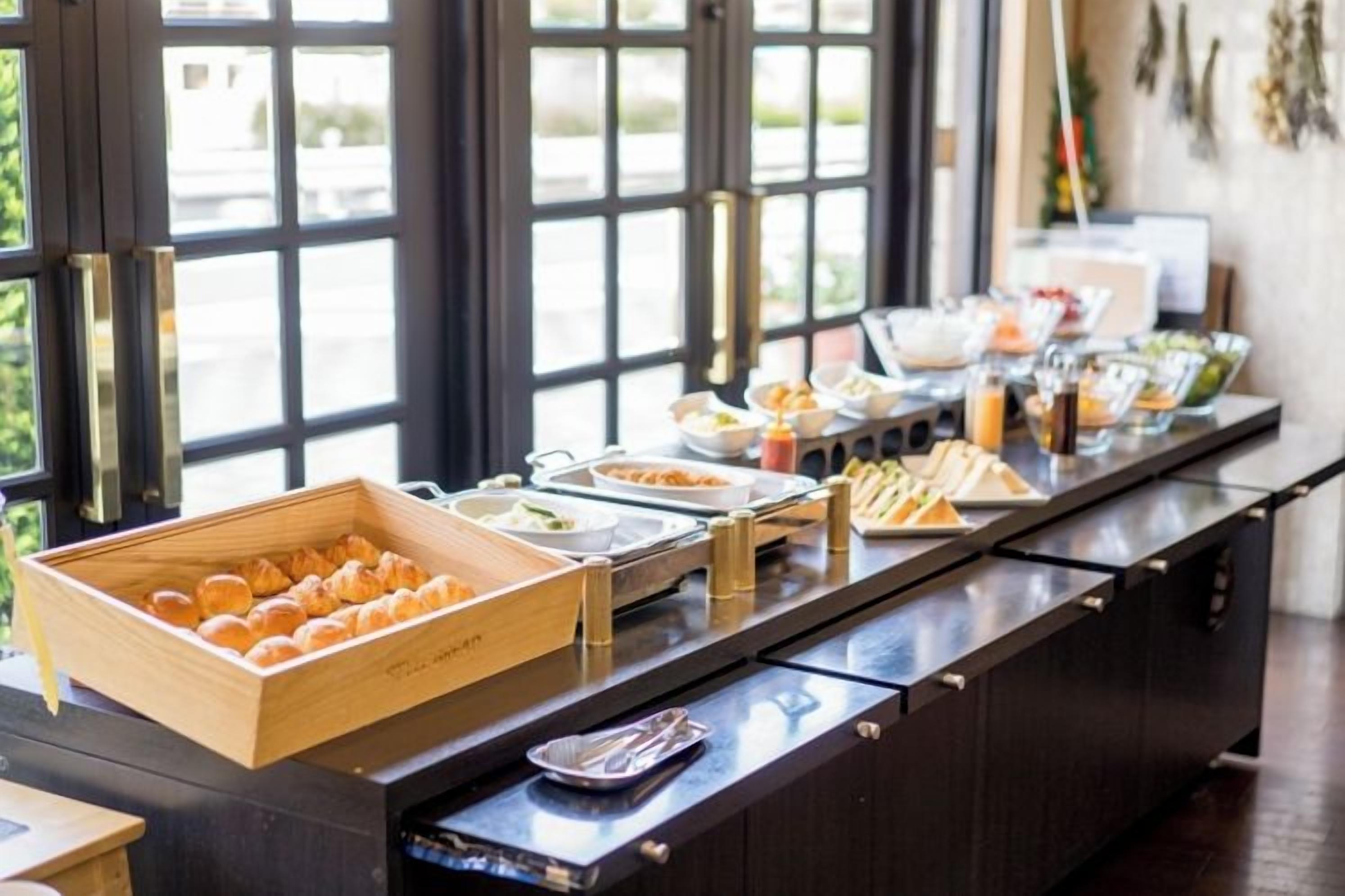 A buffet setup with various food items and a wooden box of pastries.