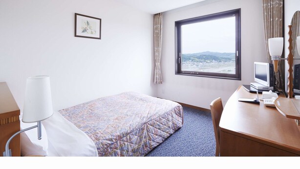 A hotel room with a bed, a desk, a computer, and a window with a view of the landscape. - Hotel Melxe (Sanda)