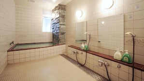 Un baño con bañera, ducha, espejo y toallero.