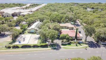 An aerial view of a residential area with houses, a playground, and a road.