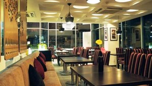 Un restaurant doté d’un long comptoir, de banquettes et de hauts plafonds avec des luminaires encastrés.