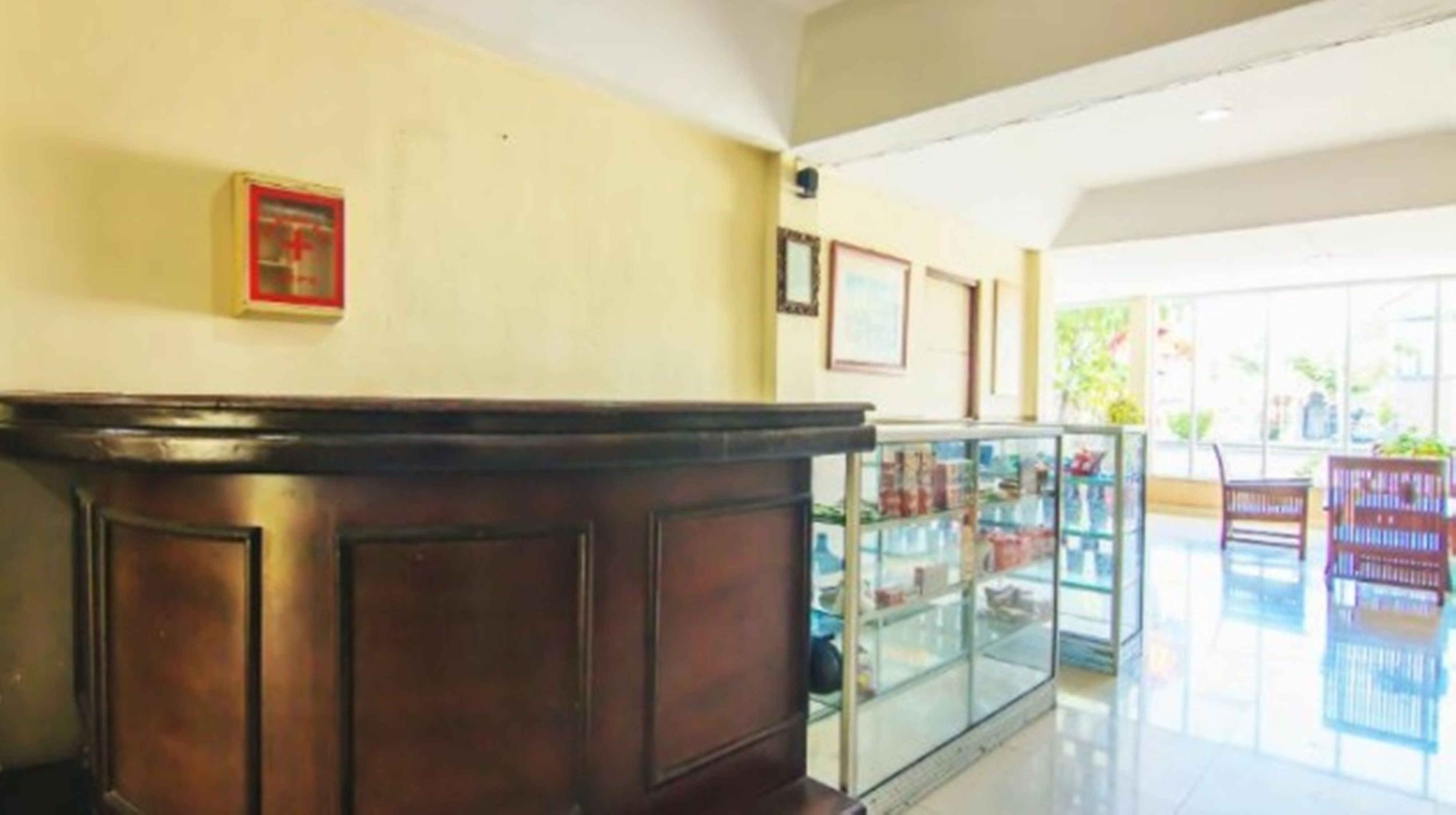 A reception area with a wooden reception desk, glass display cases, and framed pictures on the wall.