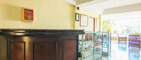 A reception area with a wooden reception desk, glass display cases, and framed pictures on the wall.