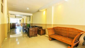 A spacious lobby with a wooden bench and a small table, a tiled floor, and a doorway leading to another room. - Sanur Ayu Hotel (Denpasar)