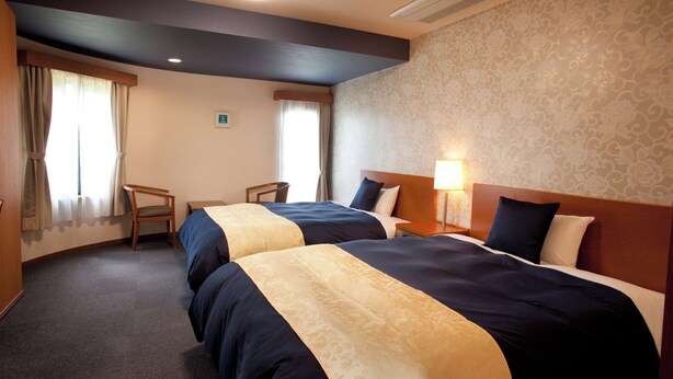 A hotel room with two beds, a desk, and a chair. - Business Hotel Shinten (Imari)