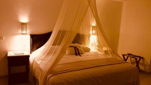 A bed with a canopy, bedside tables, and wall-mounted lamps. - Hotel María Jose (Mérida)