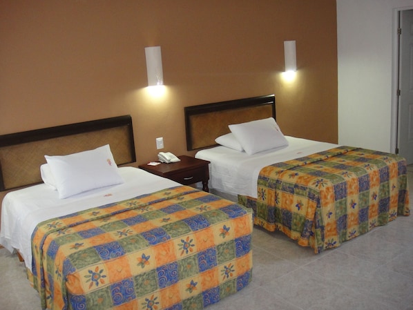 Two single beds with headboards, a bedside table with a phone, and a wall-mounted light fixture. - Hotel María Jose (Mérida)