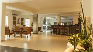 A spacious living area with a dining set, kitchen area, and a large potted plant. - Hotel María Jose (Mérida)