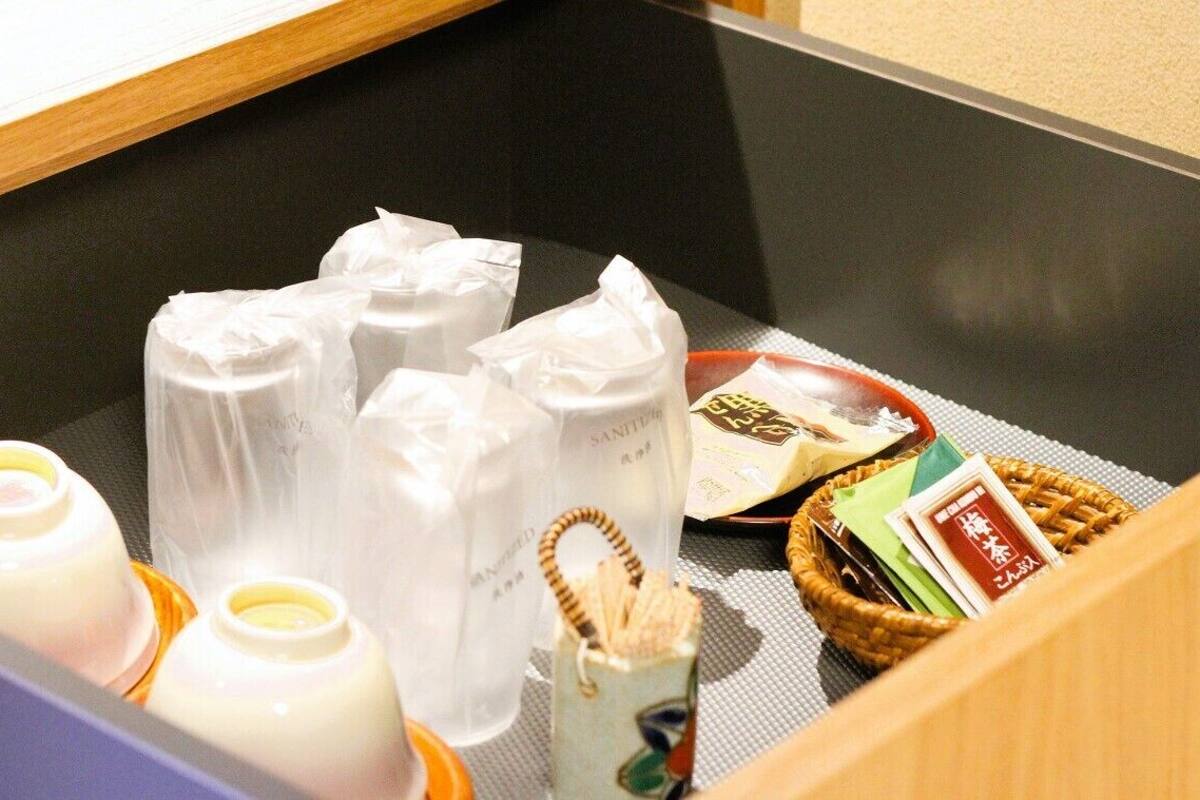 A table with toiletries, a basket of snacks, and a magazine.