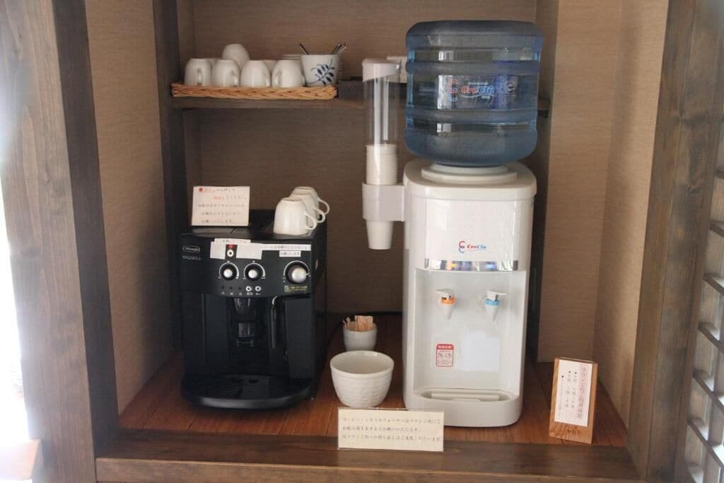 A coffee machine and a water dispenser on a wooden counter.