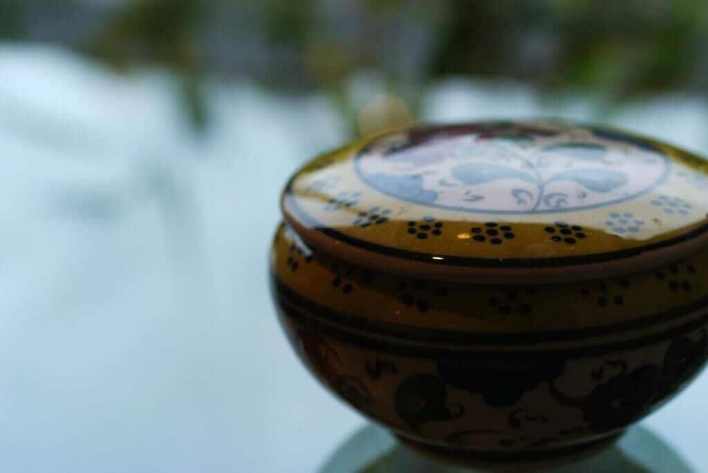 A ceramic bowl with a floral pattern on a reflective surface.