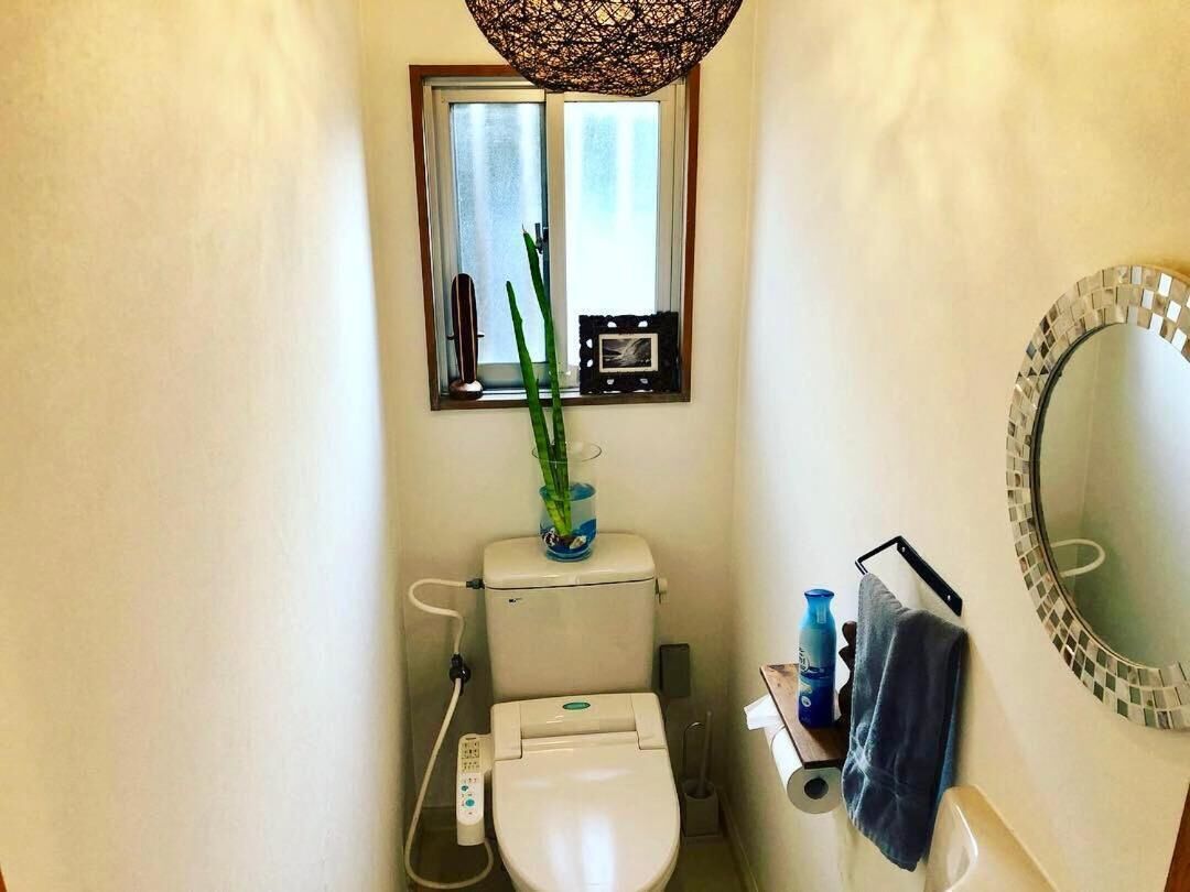 A compact bathroom with a toilet, bidet, and a small window.