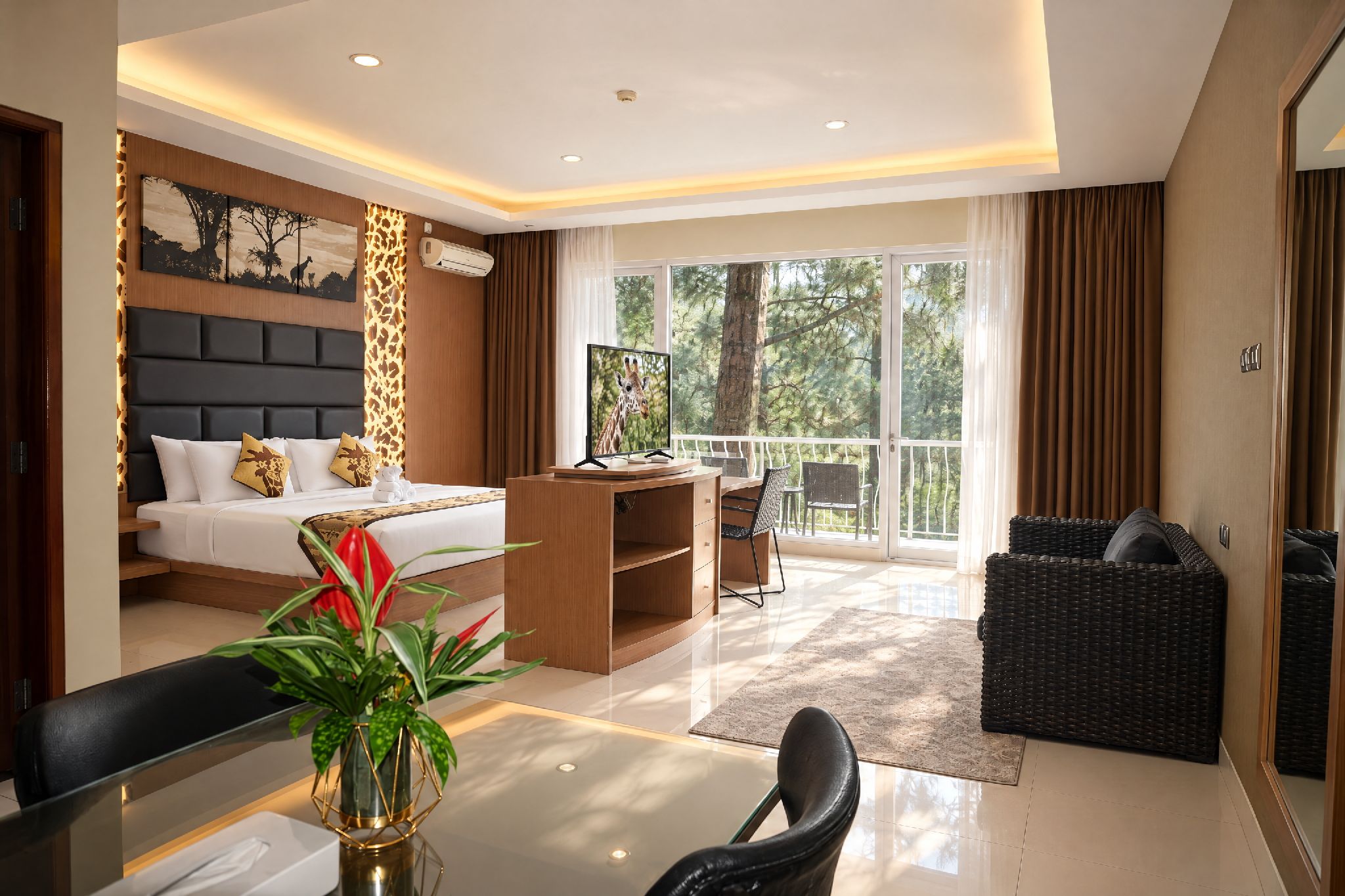 A modern hotel room with a bed, desk, and balcony.