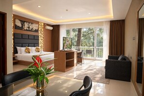 A modern hotel room with a bed, desk, and balcony. - Royal Safari Garden Resort & Convention (Cisarua)