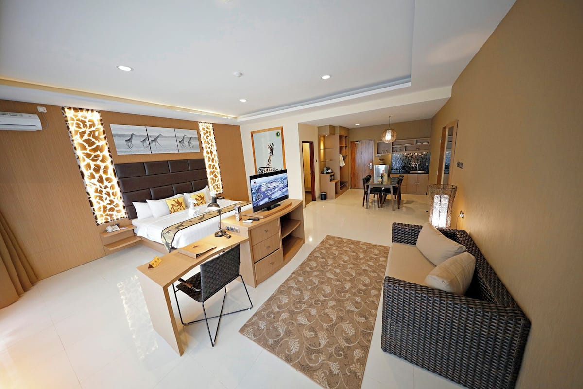 Une chambre d’hôtel moderne équipée d’un lit, d’un bureau et d’un coin salon.