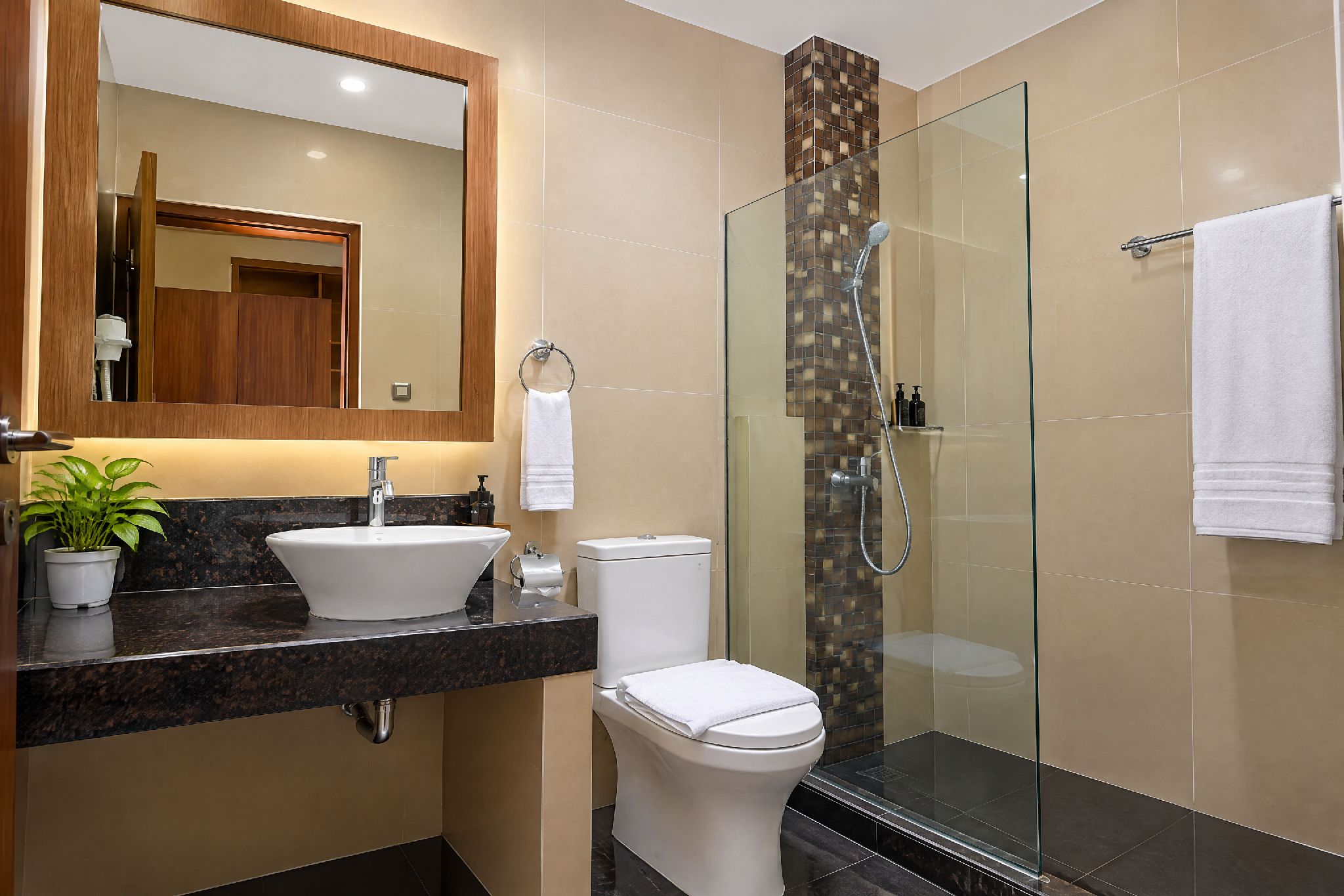 A modern bathroom with a sink, toilet, and glass-enclosed shower.