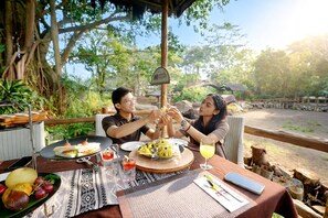 A dining table with food, drinks, and a sign indicating a safari garden. - Royal Safari Garden Resort & Convention (Cisarua)