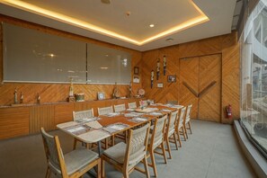 Ein Essbereich mit einem langen Holztisch, gepolsterten Stühlen und einem modernen Deckenstil.
