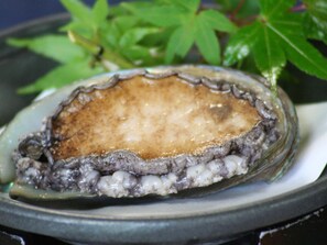 A plate with a single oyster on a dark plate. - Kimiideraonsen Hananoyu Garden Hotel Hayashi (Wakayama)