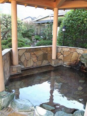A stone-walled hot spring area with a wooden pavilion, surrounded by greenery. - Kimiideraonsen Hananoyu Garden Hotel Hayashi (Wakayama)