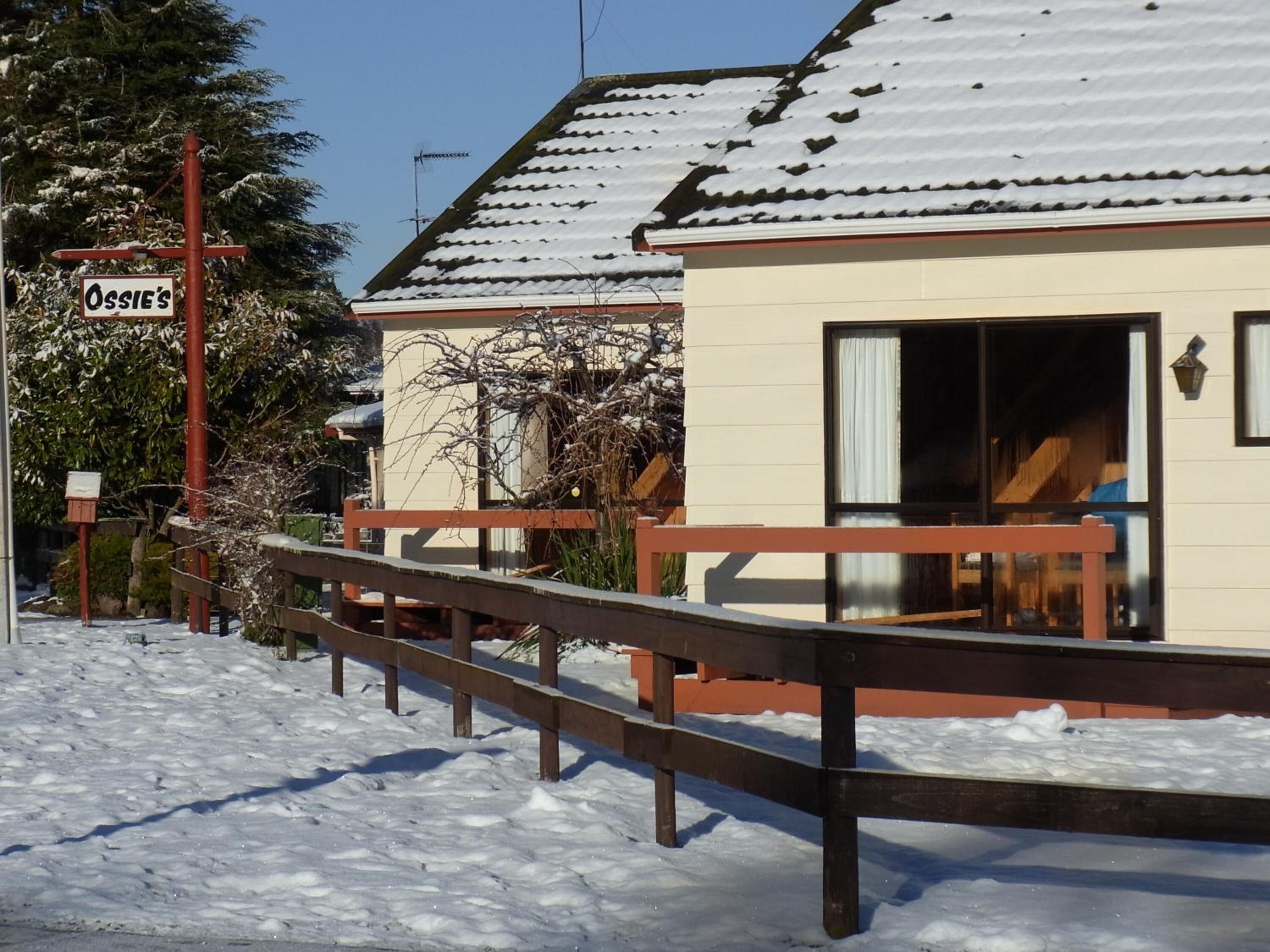 A snow-covered building with a sign reading "Ossie's".