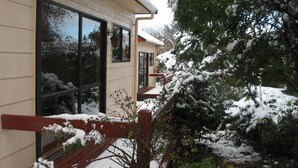 A house with large windows and a wooden deck.