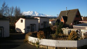 A row of small, single-story houses with a mountain in the background.