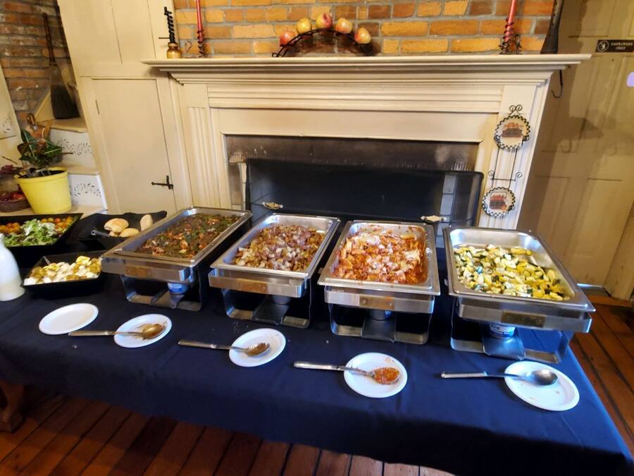Une table de buffet avec différents plats et assiettes.