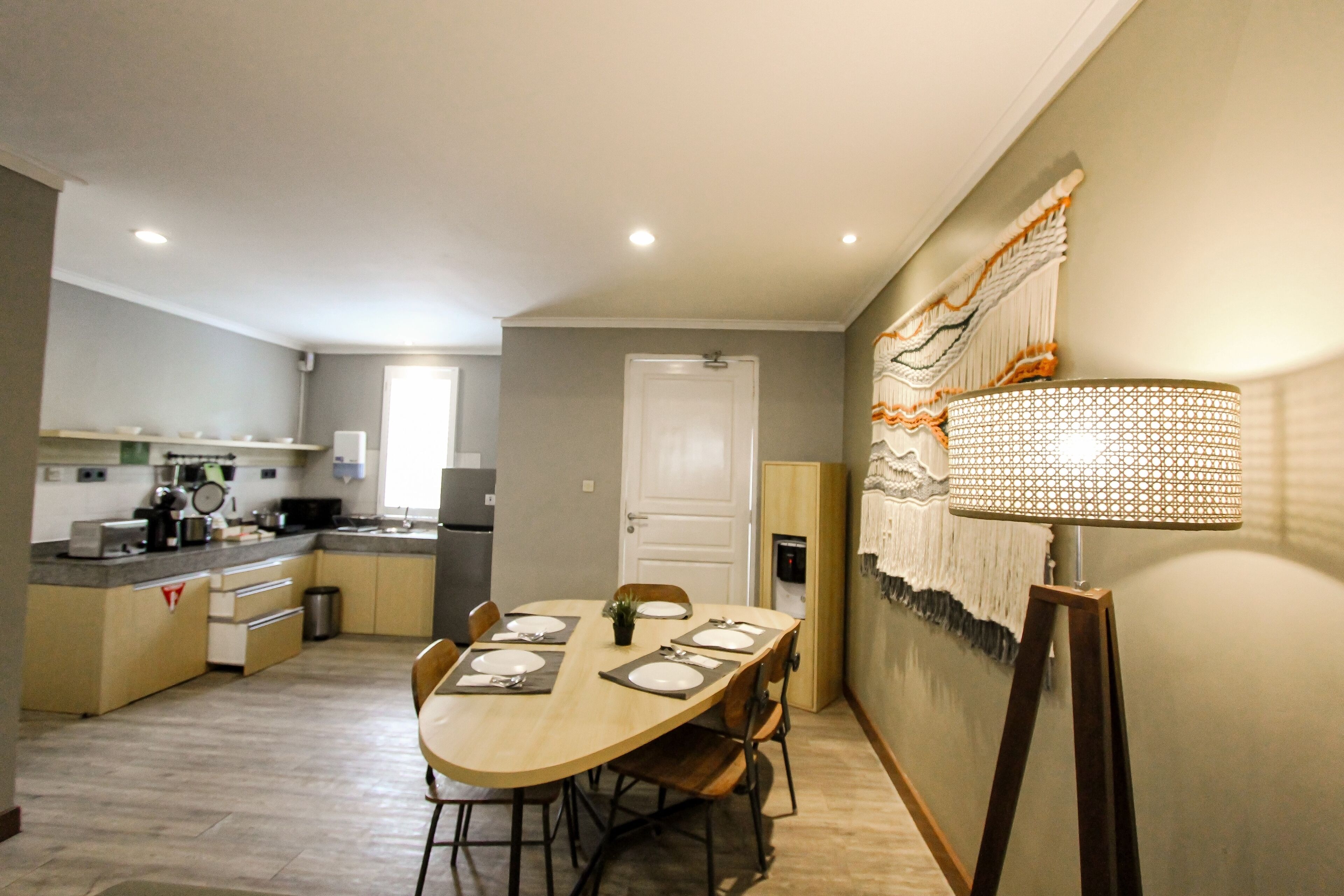 A modern kitchen with a dining table set for four, a microwave, and a refrigerator.