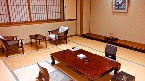 A tatami mat room with a wooden table, chairs, and a small cabinet. - Hamasaka Onsen Totoya (Shinonsen)