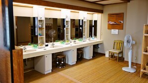 A bathroom with a long vanity, multiple mirrors, and a fan. - Hamasaka Onsen Totoya (Shinonsen)