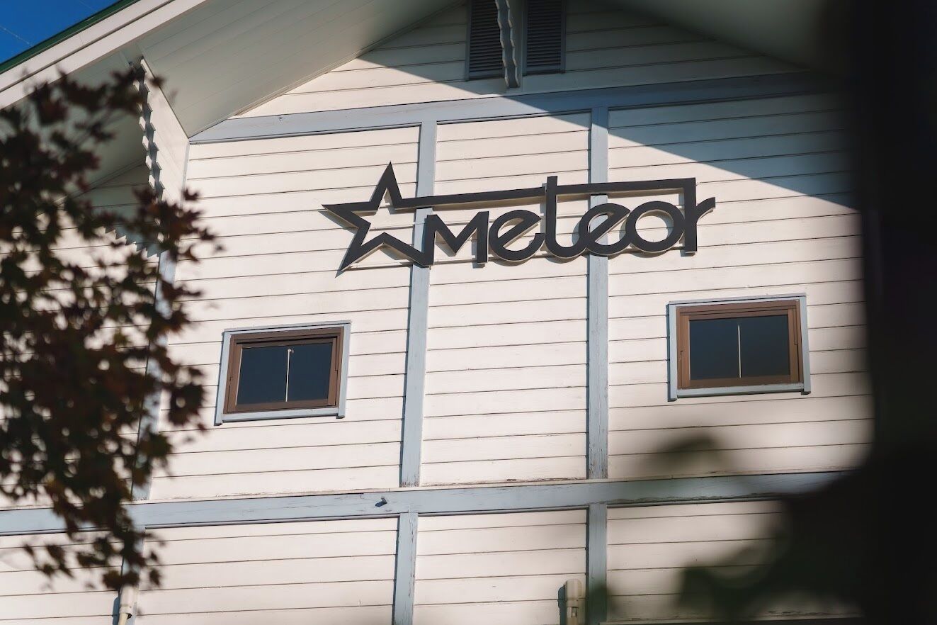 A building with a sign that reads 'Meteor' and two windows.