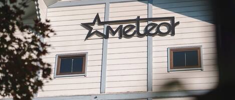 A building with a sign that reads 'Meteor' and two windows.
