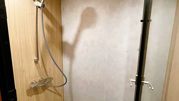 A small, enclosed shower area with a wooden door and a glass partition. - Hakuba Pension Meteor (Hakuba)