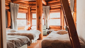 A cabin with two beds, wooden walls, and large windows. - Hakuba Pension Meteor (Hakuba)