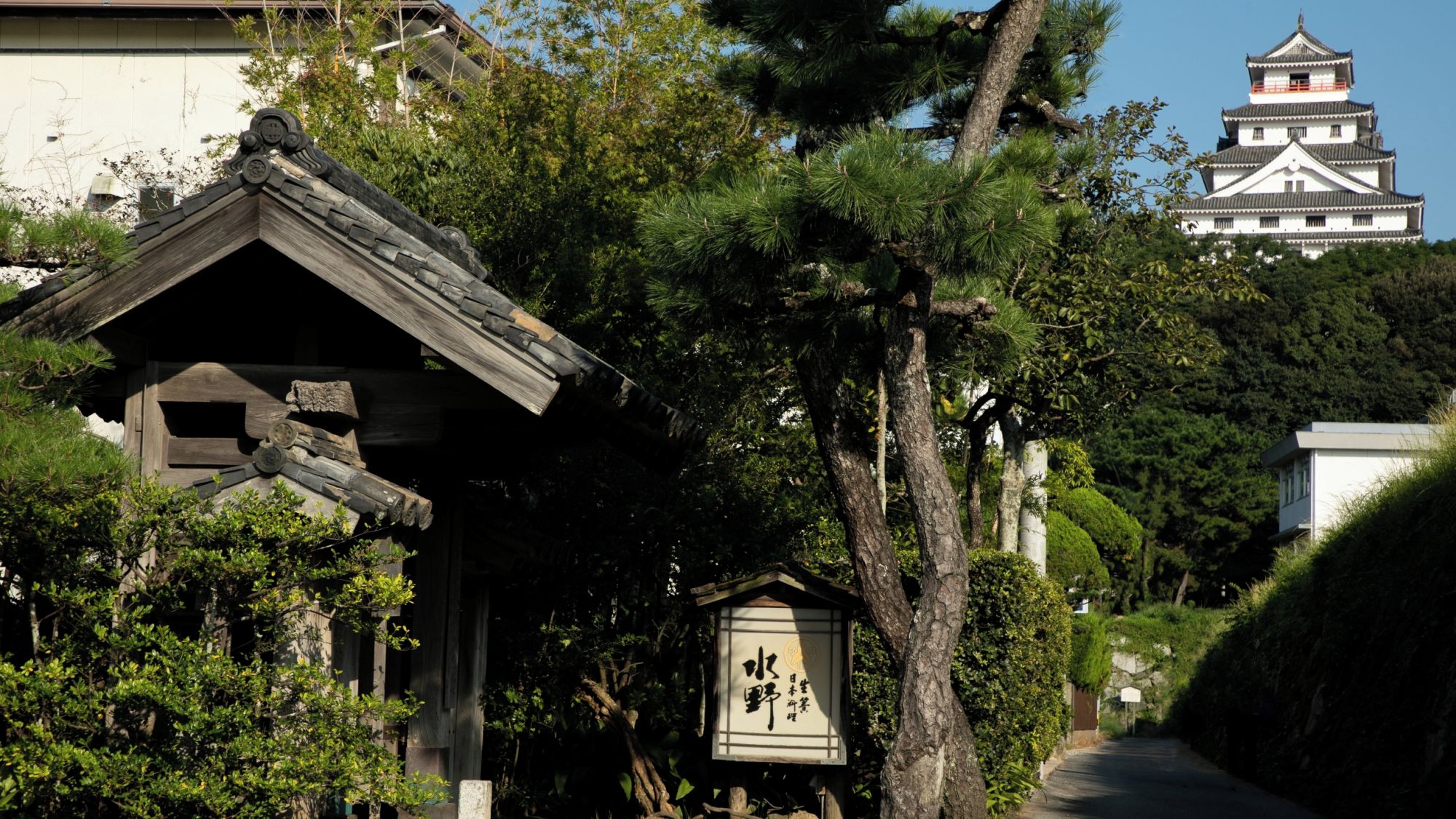 A traditional Japanese building with a wooden structure and a signboard.