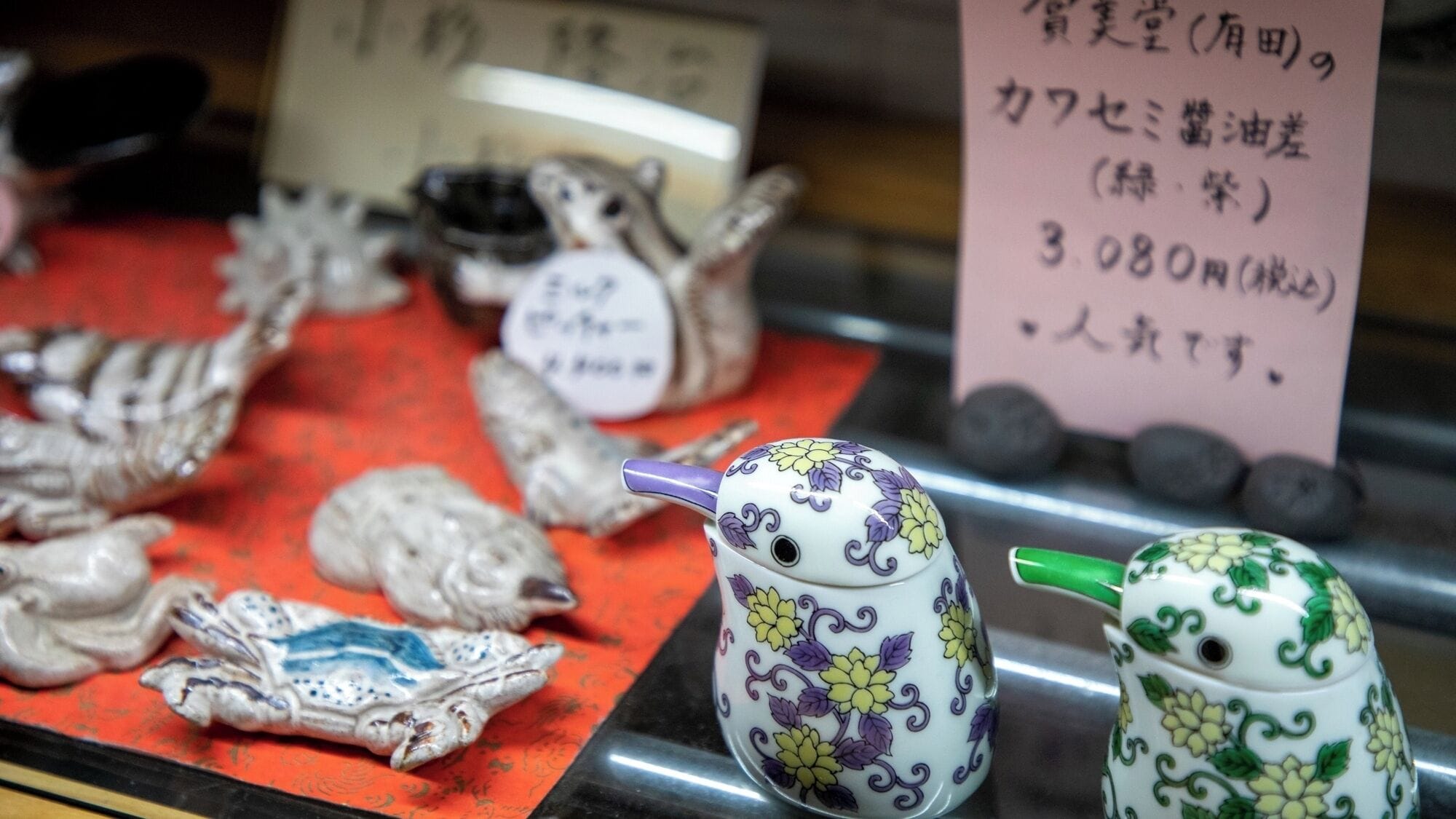 A display of ceramic figurines and teapots with floral patterns, priced at 3080 yen.