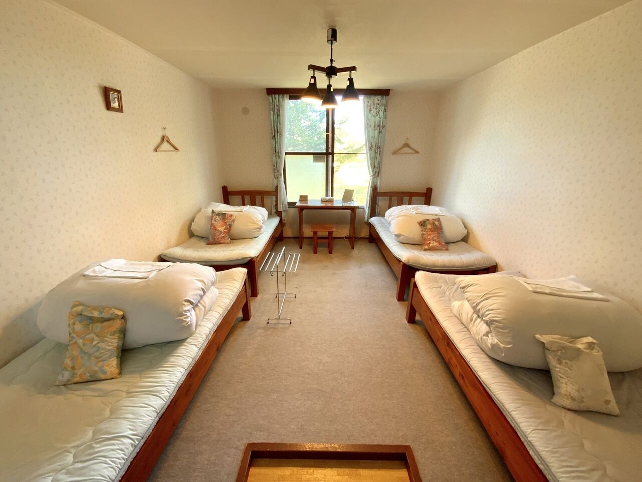 A room with two sofas facing each other, a small table, and a hanging light fixture.