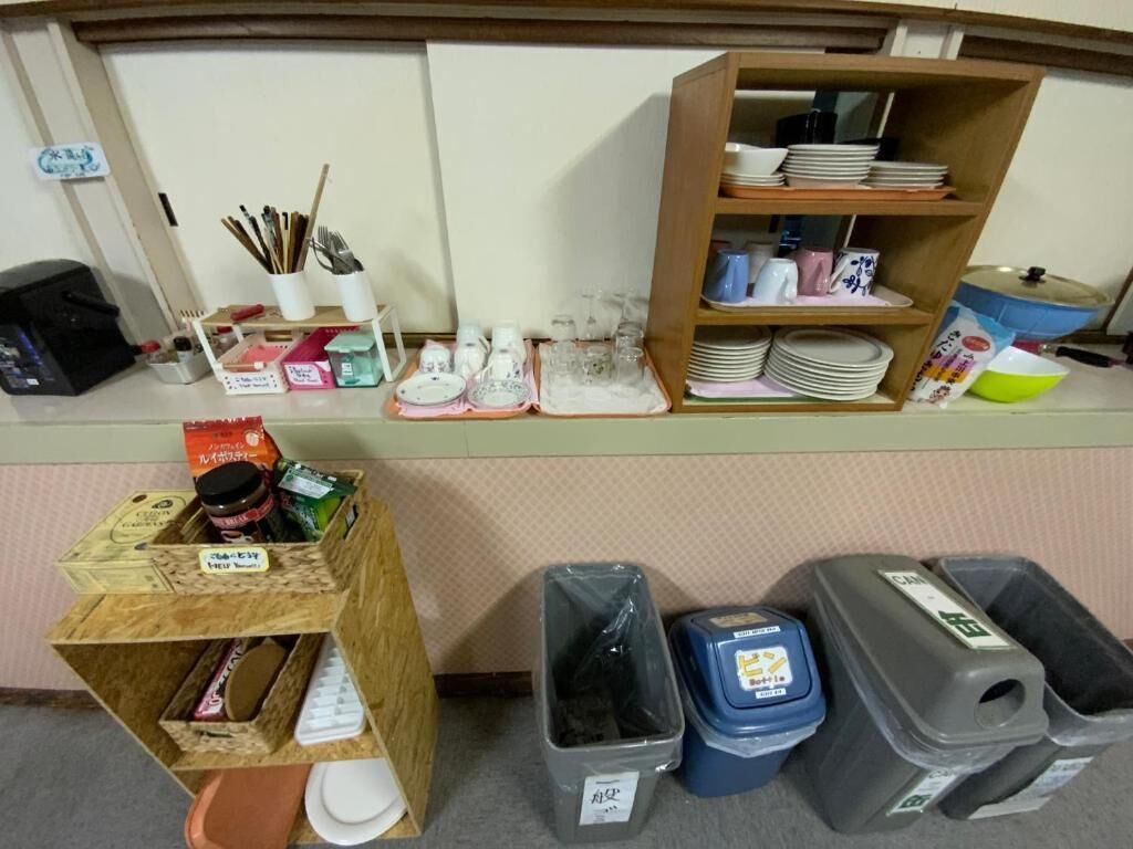 A kitchen counter with various utensils, plates, and containers.