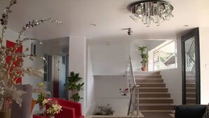 A modern interior with a staircase, red chairs, and a chandelier. - Micasa Lodge Palawan (Coron)
