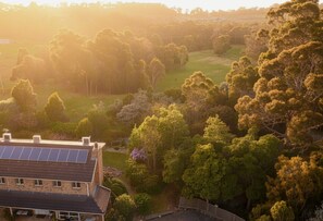 A residential area with a house featuring solar panels, surrounded by dense trees and a grassy field. - Waterview Gardens B&B (Margate)
