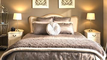 A bed with a textured blanket, two bedside tables with lamps, and decorative wall art.