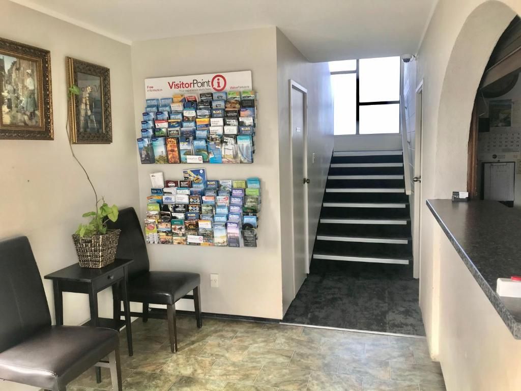 A reception area with a wall of brochures, a staircase, and a counter.