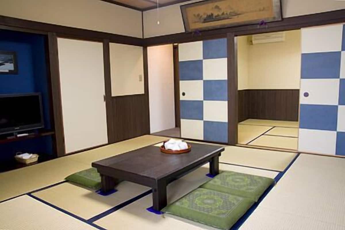 Une pièce de style japonais traditionnel, avec un sol recouvert de tatamis, une table basse et des paravents en papier.