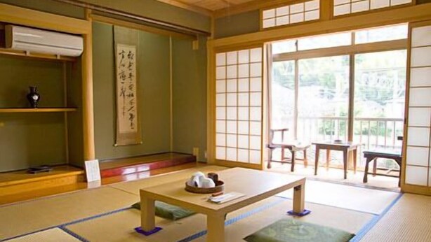 A traditional Japanese room with tatami flooring, a low wooden table, and sliding shoji doors.