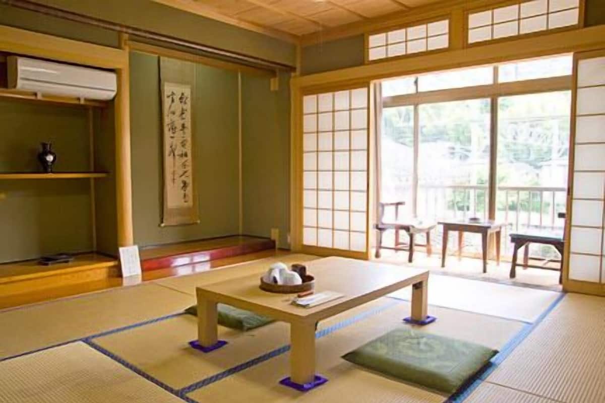 Une pièce de style japonais traditionnel, avec un sol recouvert de tatamis, une basse table en bois et des portes coulissantes en papier de riz (shoji).