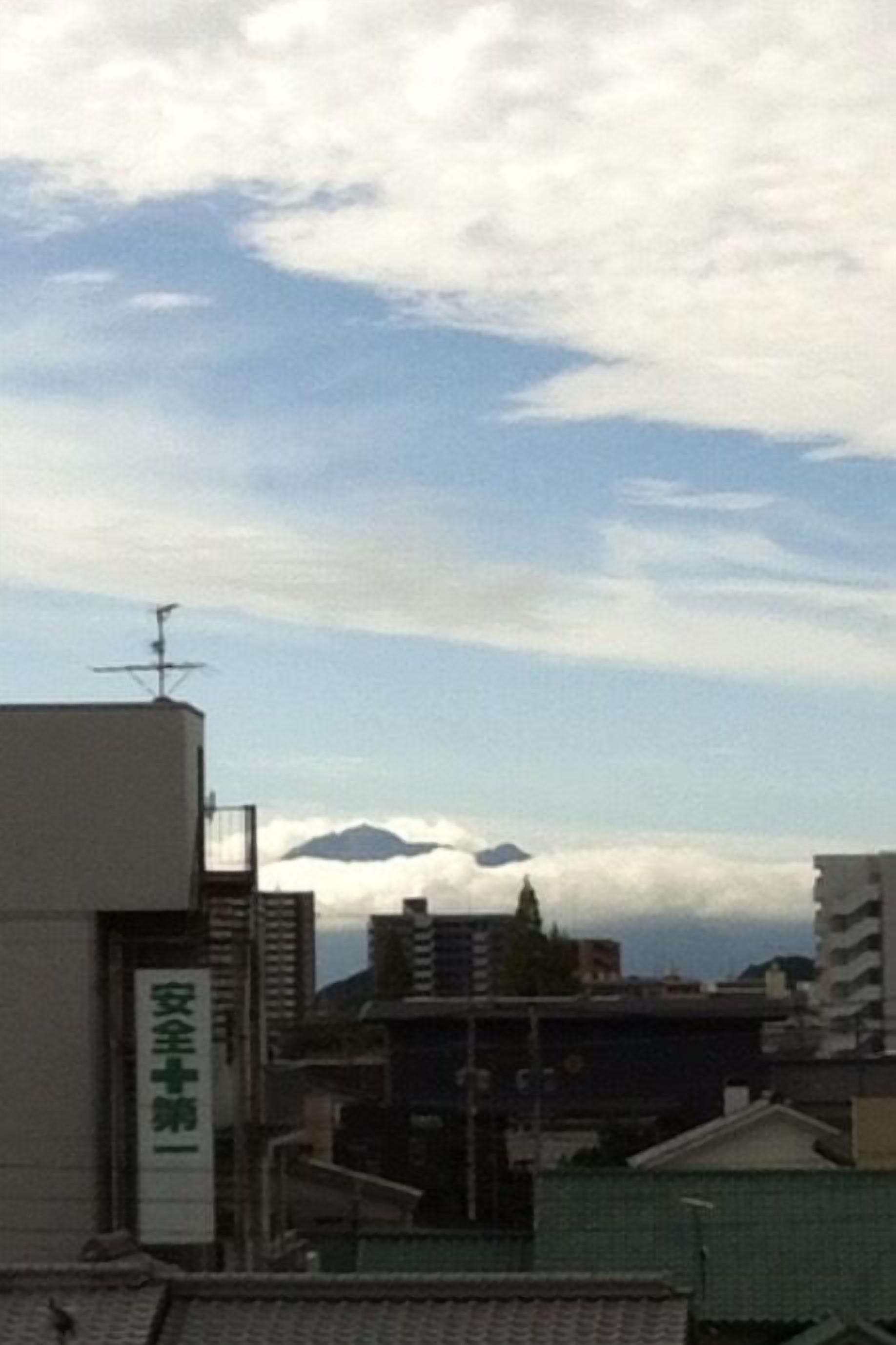 A building with a sign reading '安全第一' and a mountain in the background.
