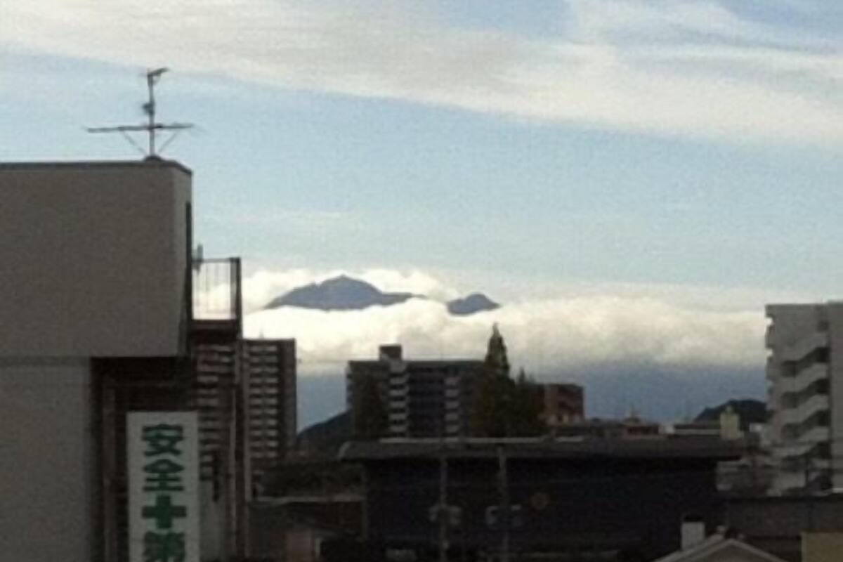 A building with a sign reading '安全第一' and a mountain in the background.