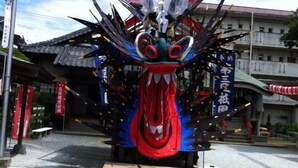A traditional Japanese festival float with a dragon head, surrounded by spectators. - Business Hotel Mayumi (Omuta)