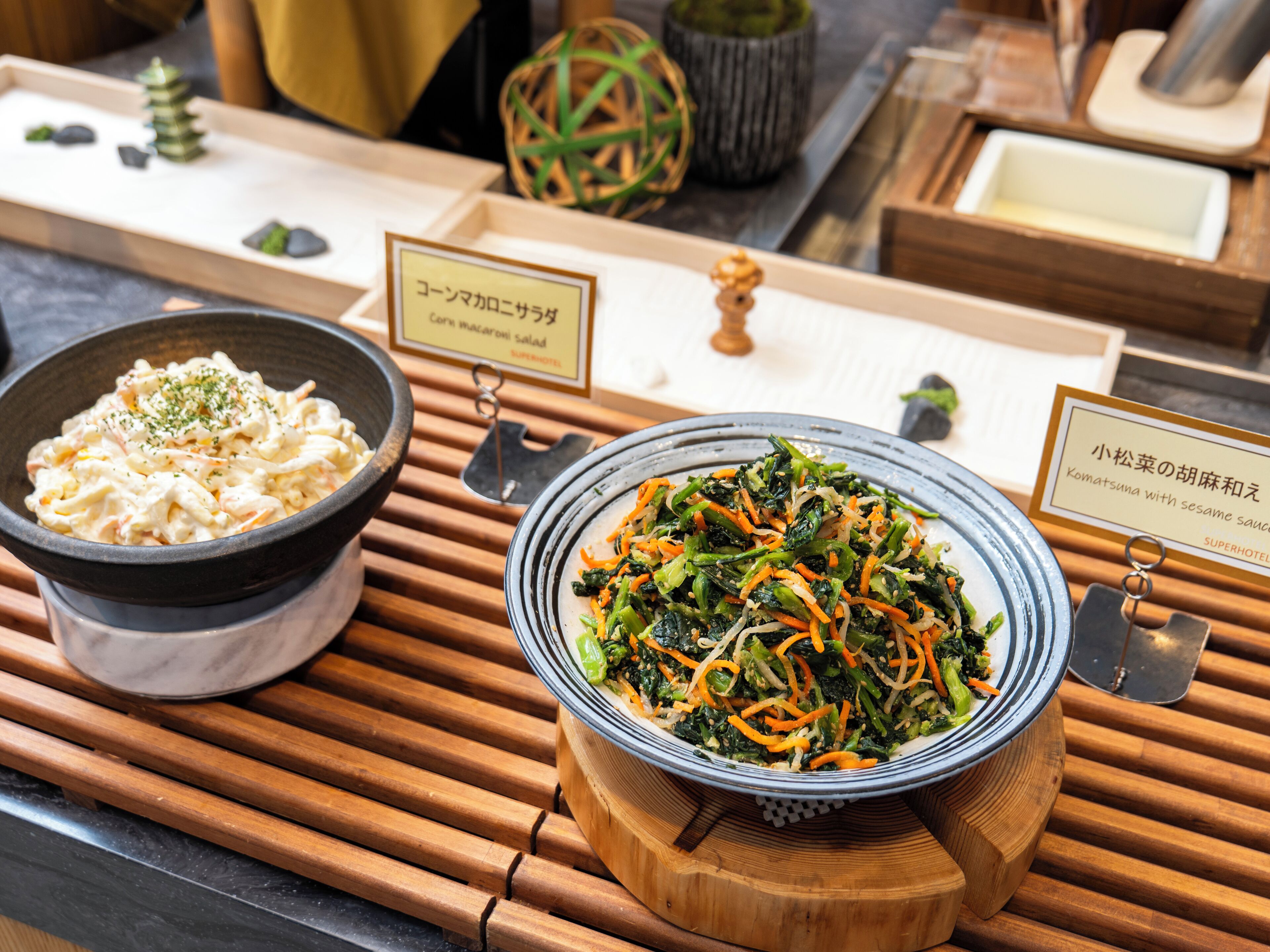 A buffet table with two dishes: a creamy salad and a vegetable stir-fry.